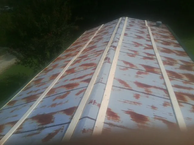 Rusted metal roof panels with new wood purlins before replacement — Storm Damage Roof Repair in Dougherty by Roofing Brothers