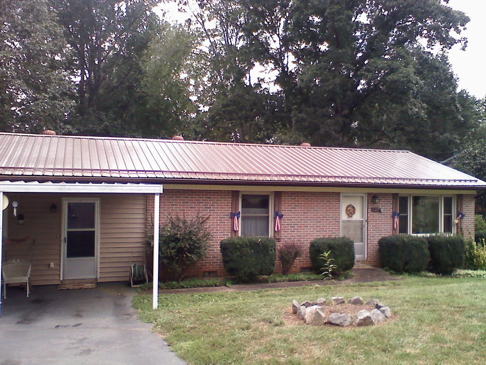 Bronze metal roof and carport on a brick ranch home — Roof Repair work by our crew in Dougherty