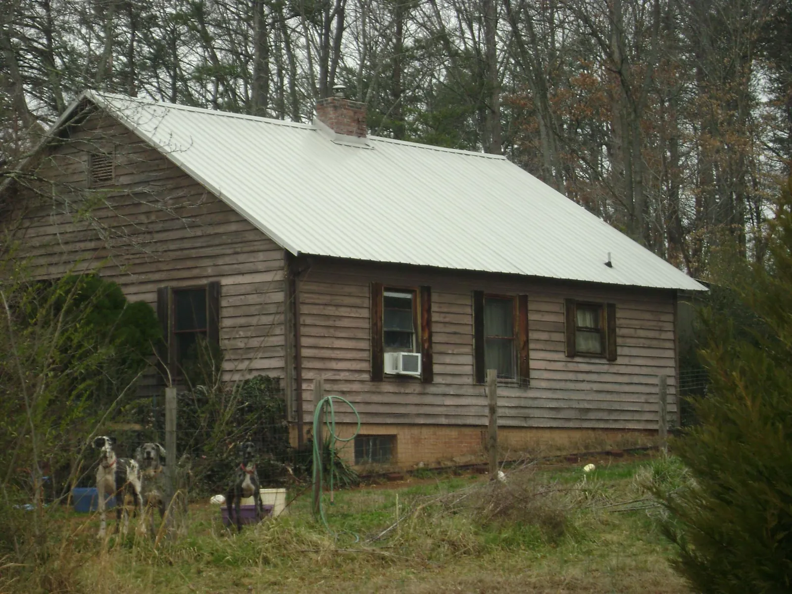 White metal roof on an old wood sided farmhouse, from a Metal Roof Installation job in Dougherty